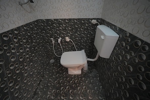 Een badkamer met toilet, douche en wastafel.