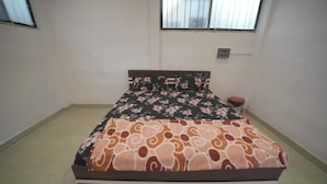 Un dormitorio con una cama, una ventana y una mesita de noche.
