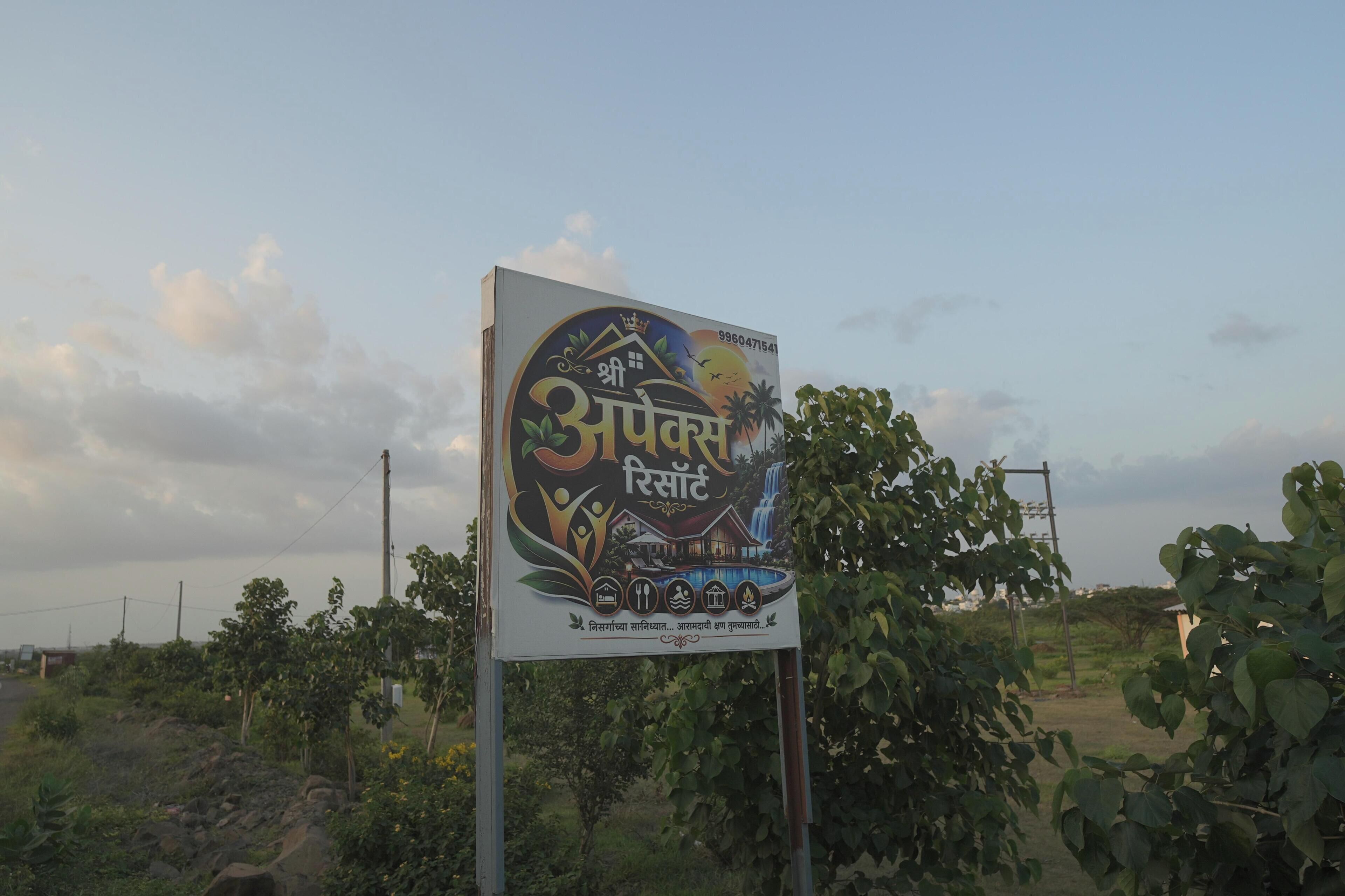 A signboard with text and symbols indicating a hotel or resort.