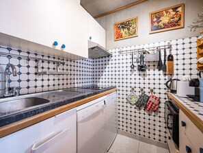 A kitchen with a sink, dishwasher, and tiled backsplash. - Bright apartment village view - 6 guests (Val-d'Isère)