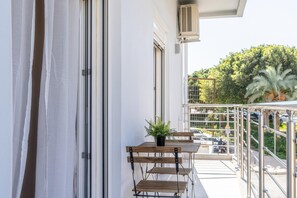 A balcony with a potted plant, a table, and chairs. - Pananos Sq. House I (Heraklion)