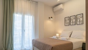 Una habitación de hotel con una cama, una mesita de noche, una lámpara y obras de arte en la pared.