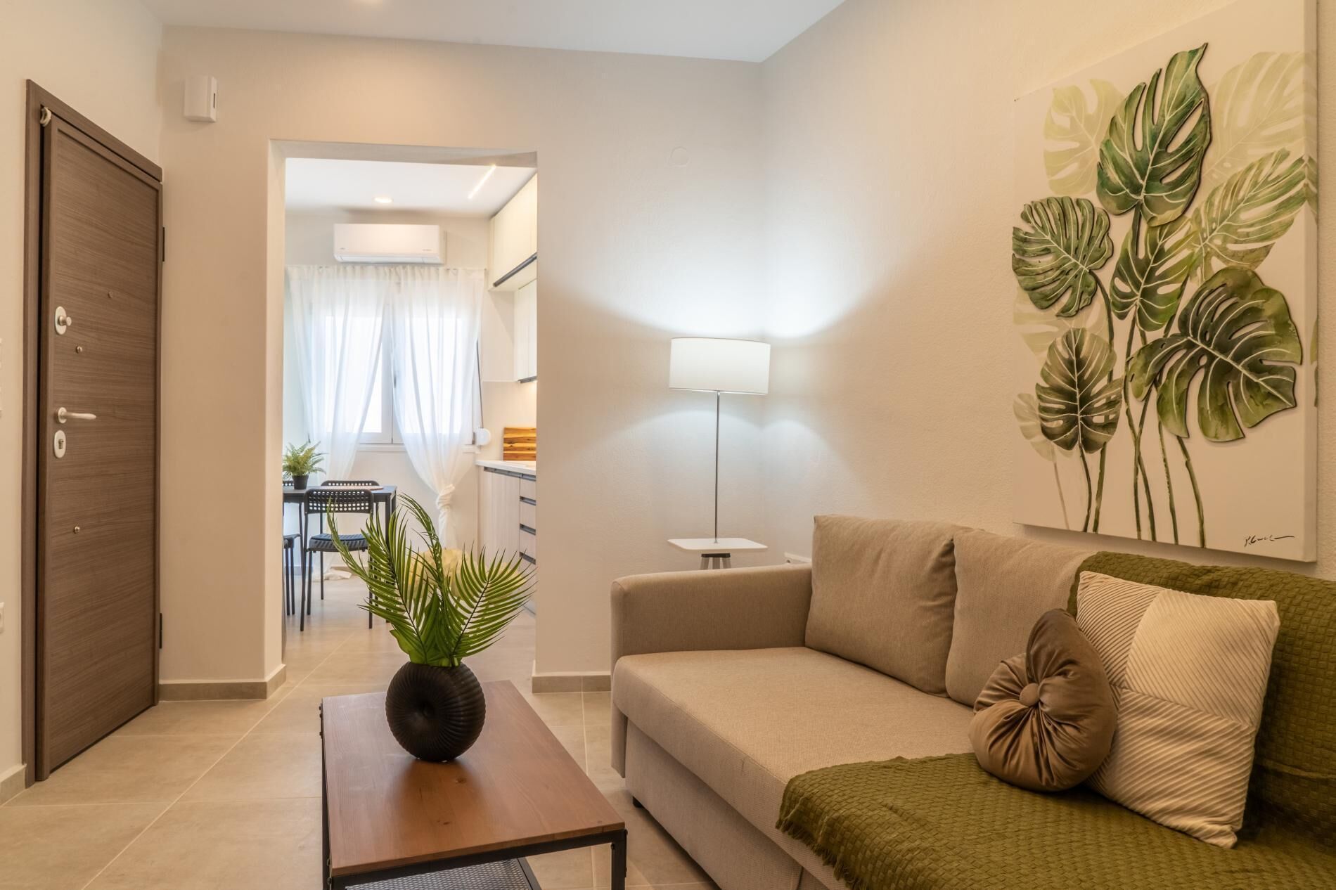 Un salon moderne avec un canapé, une table basse, une lampe et une plante.