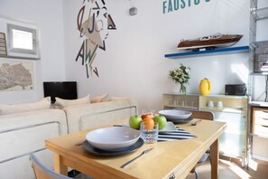 Ein modernes Wohnzimmer mit Essbereich, einem Flachbildfernseher, einer Couch und einer Wand mit einer dekorativen Karte und Text.