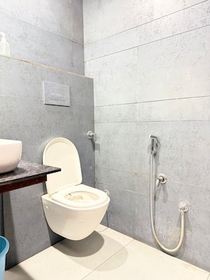 A bathroom with a toilet, a shower, and a sink. - Hotel M9 (Ludhiana)