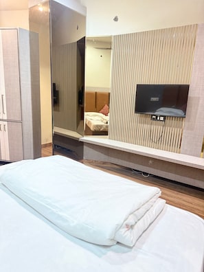 A hotel room with a bed, a mirror, a television, and a wardrobe. - Hotel M9 (Ludhiana)