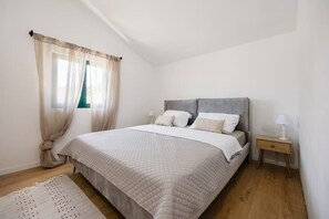A bedroom with a bed, curtains, a nightstand, and a lamp. - Villa Jadra (Kornati)