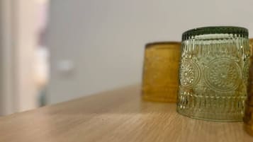 Una superficie in legno con due contenitori di vetro, uno con una texture decorativa e l'altro liscio.