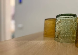 Eine Holzoberfläche mit zwei Glasbehältern, einer mit strukturierter Oberfläche und dem anderen mit glatter Oberfläche.
