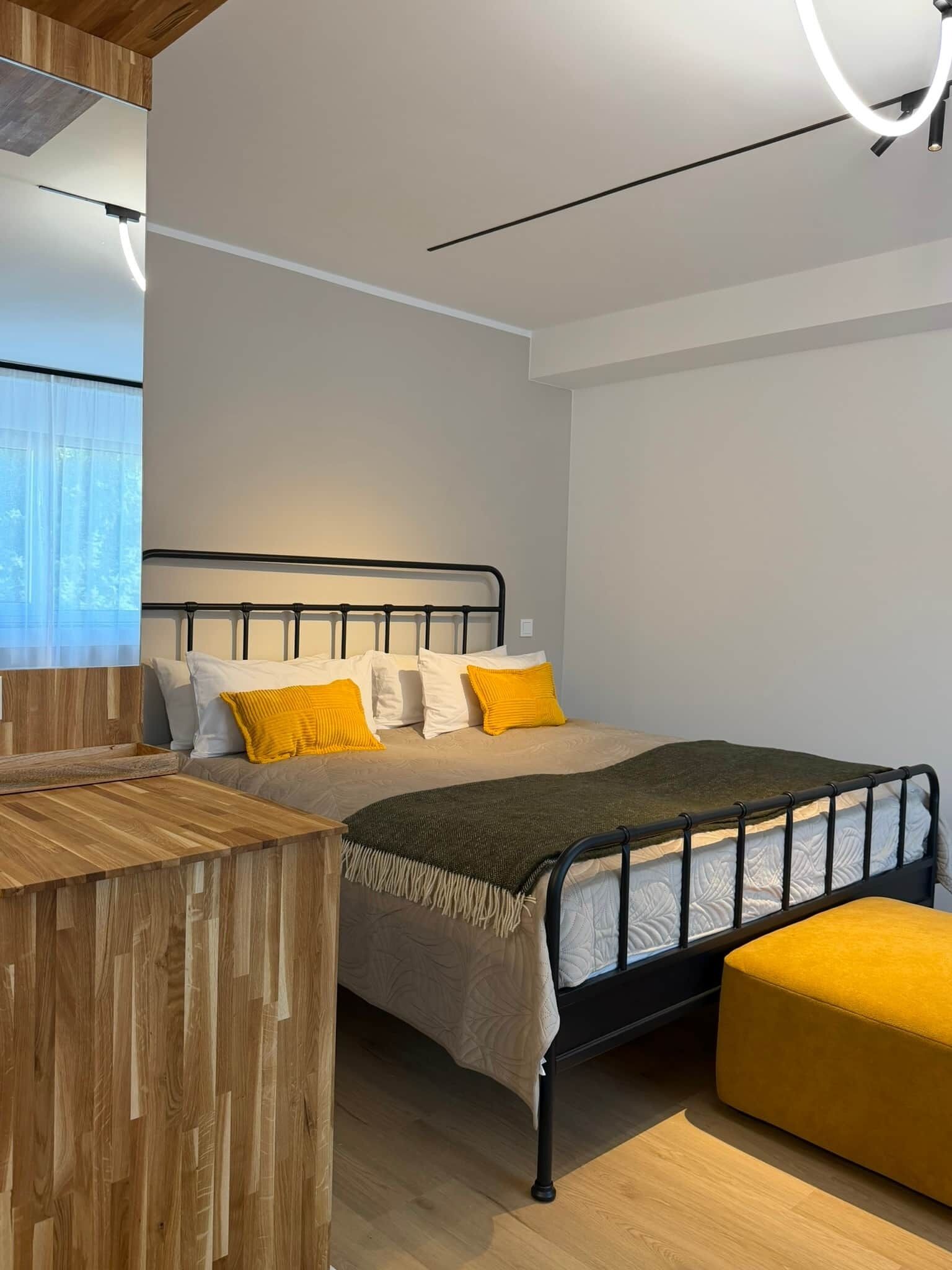 Ein modernes Schlafzimmer mit einem Bett, Nachttisch und Fenster.