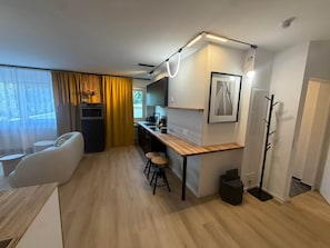 Eine moderne Küche mit einer Holzarbeitsplatte, Barhocker und einem eingebauten Backofen.