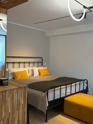 A modern bedroom with a bed, bedside table, and a circular light fixture.