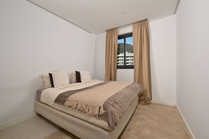 A bedroom with a bed, curtains, and a view of buildings. - Modern Apartment with Terrace in Higueron (Fuengirola)