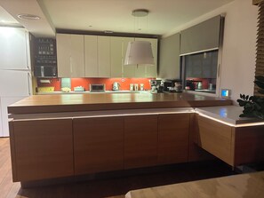 A modern kitchen with a large island, built-in appliances, and a pendant light. - Stunning 80 m² loft with air conditioning and private parking, near the Old Town and the lake (Annecy)