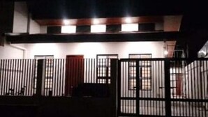 A building with a gated entrance, multiple windows, and a visible door. - Cozy 3BR Home in Quezon City (Quezon City)