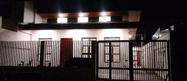 A building with a gated entrance, multiple windows, and a visible door.