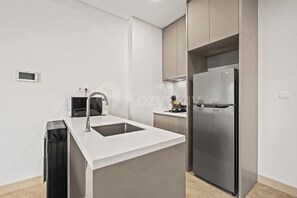 Een moderne keuken met een inbouw vaatwasser, een roestvrijstalen koelkast en een magnetron.