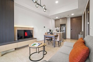 A modern living room with a flat-screen TV, a coffee table, and a sofa. - Weska by Kozystay - Cilandak (South Jakarta)