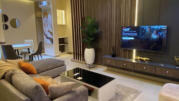 A modern living room with a sofa, coffee table, TV, and decorative elements.