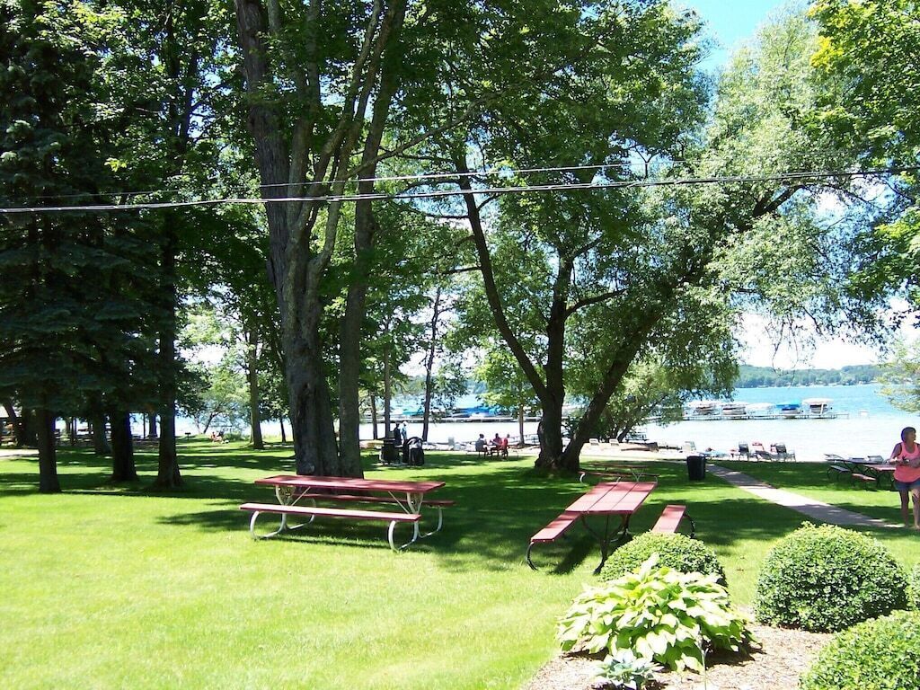 Un parc avec des tables de pique-nique et une vue sur un lac.