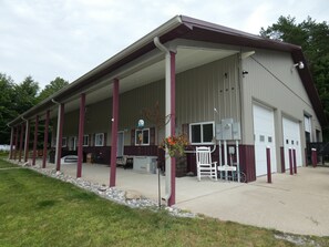 A large building with a covered porch, multiple windows, and a garage.