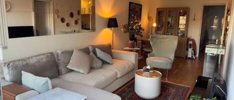 A modern living room with a sofa, coffee table, and a potted plant.