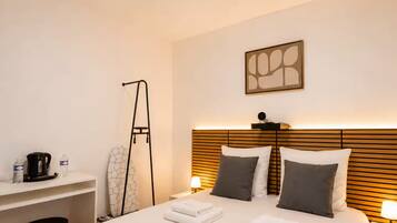 Una habitación de hotel con una cama grande, mesitas de noche, un escritorio y una silla.
