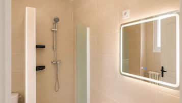 Une salle de bain avec une baignoire, une douche, des toilettes et un lavabo.
