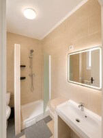 Un baño con bañera, ducha, inodoro y lavabo.