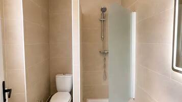 Ein Badezimmer mit Toilette, Dusche und Badewanne.