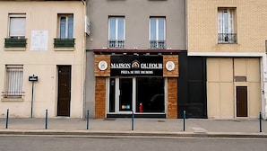 A two-story building with a sign for 'MAISON DU FOUR' indicating a pizza restaurant.