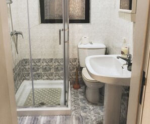 Ein Badezimmer mit Dusche, Toilette und Waschbecken.