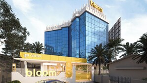 A modern building with a glass facade and a sign reading 'bloom'.