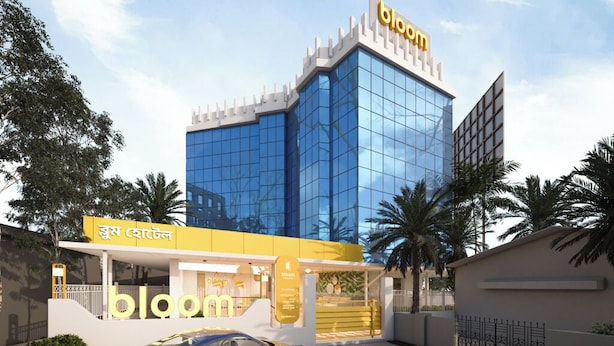 Un edificio moderno con fachada de vidrio y un letrero que dice 'bloom'.