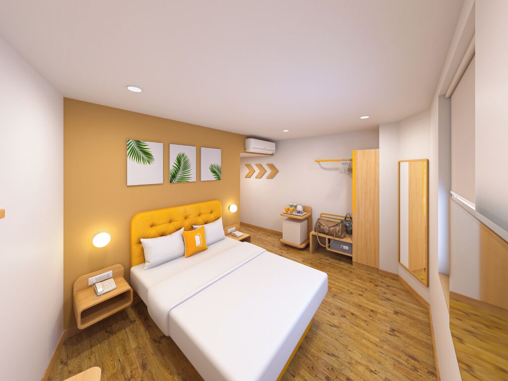 Una habitación de hotel moderna con una cama grande, mesitas de noche, un armario y un espejo.