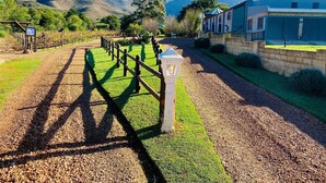 A vineyard pathway with a fence, a lamp post, and a building labeled 'AKSREST' in the background.