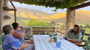 Um grupo de pessoas sentadas à mesa com vista para uma paisagem montanhosa.