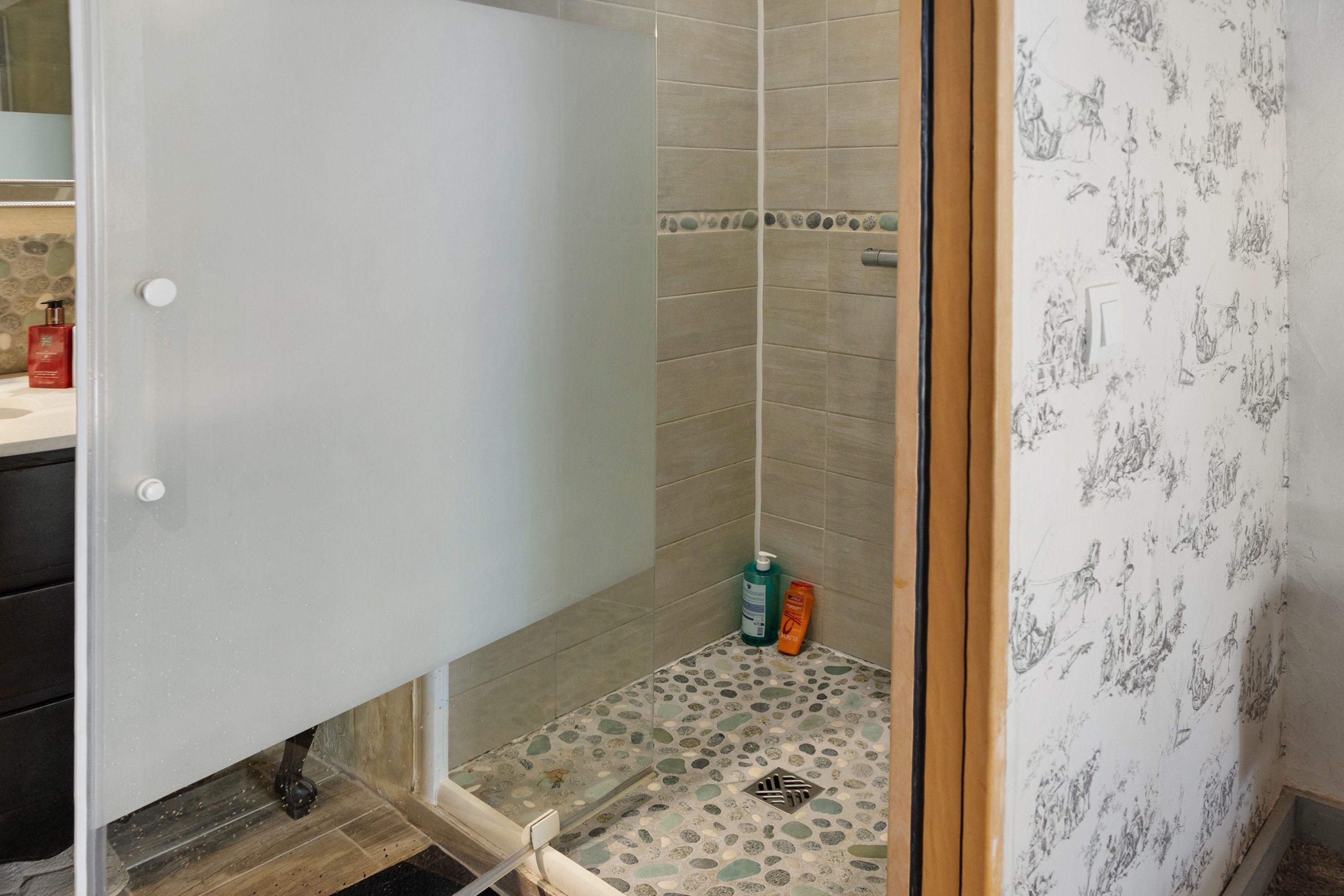 Een badkamer met een douchegedeelte, toilet en wastafel.