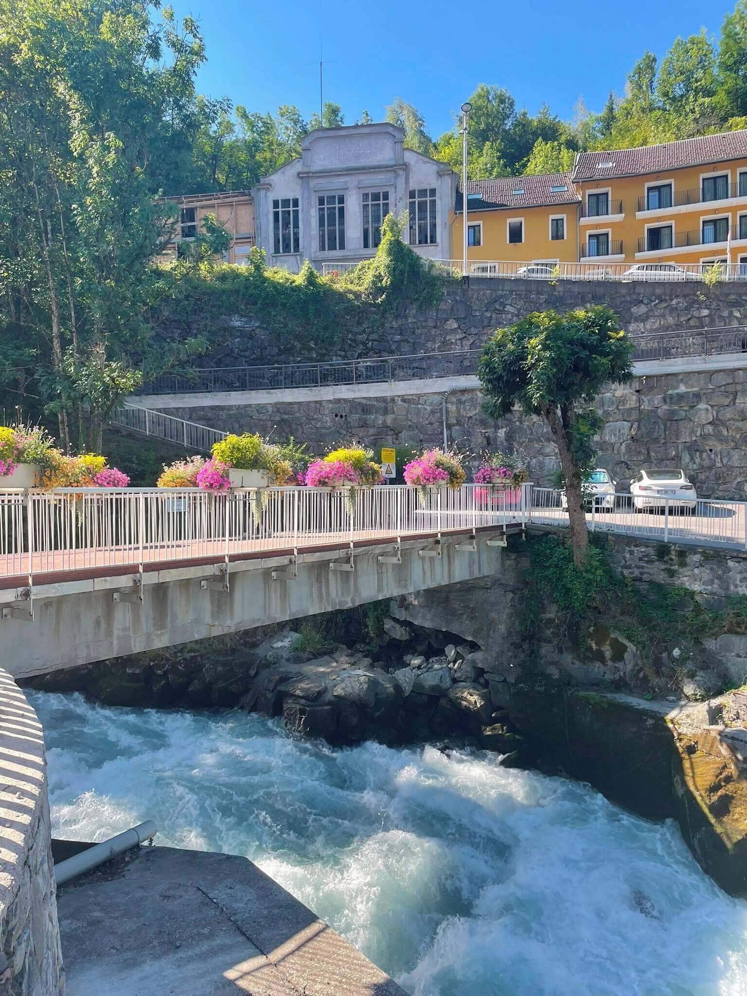 Un ponte sopra un fiume con un edificio sullo sfondo.