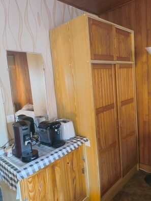 Una kitchenette equipada con cafetera, tostadora y un mantel a cuadros.