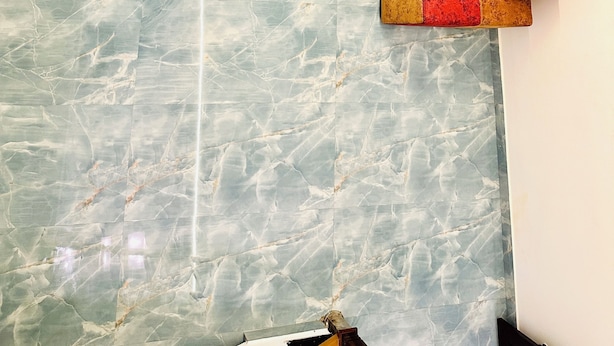 Una habitación con piso de mármol y un sofá modular en tonos rojo y beige.