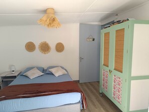 Un dormitorio con cama, armario y lámpara de pared.