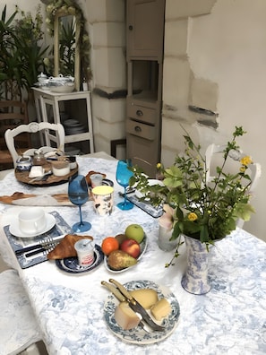 Una mesa de comedor dispuesta con platos, cubiertos, un florero con flores y un espejo.
