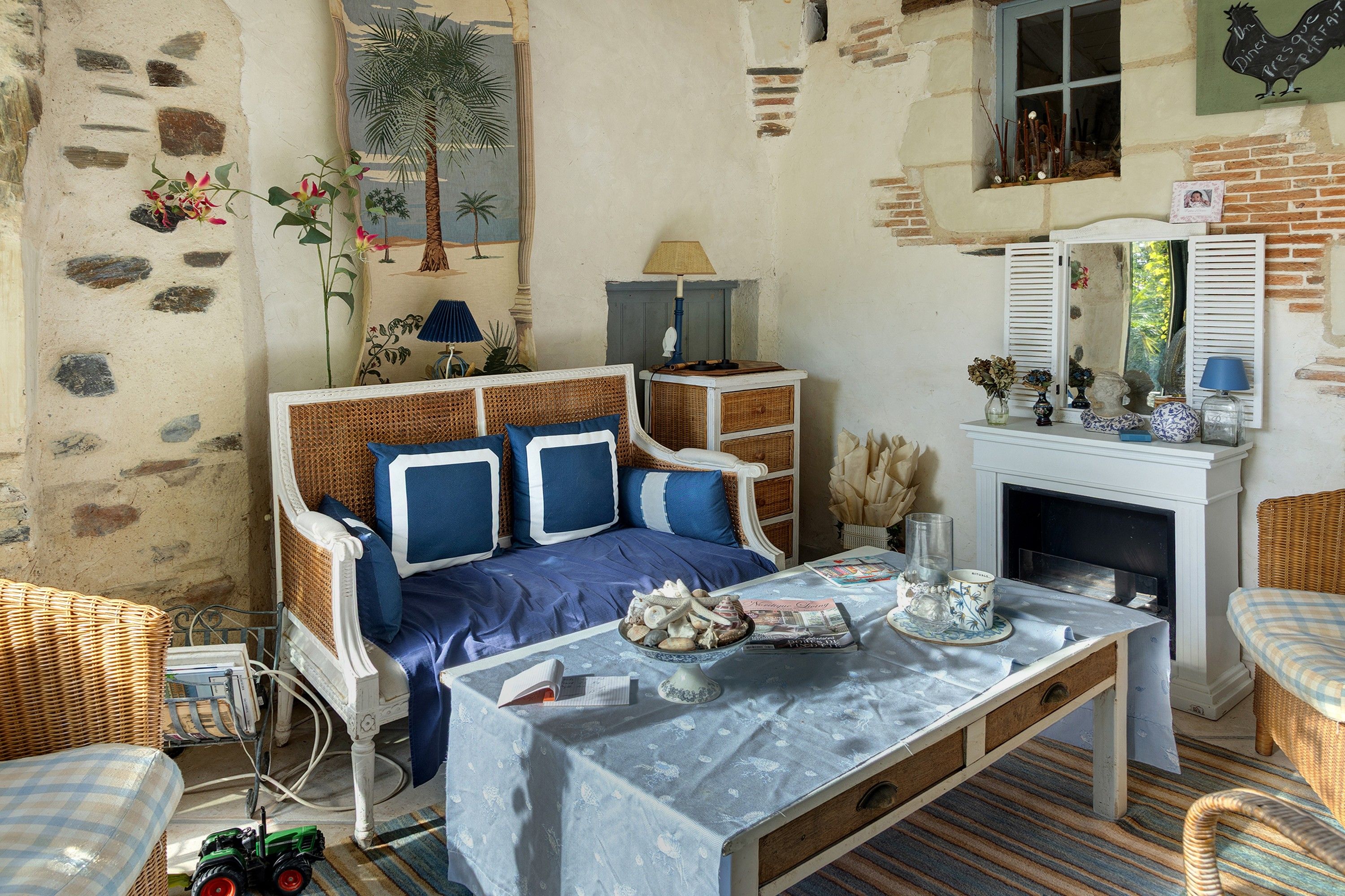 A rustic room with a bed, a fireplace, and a dining table.