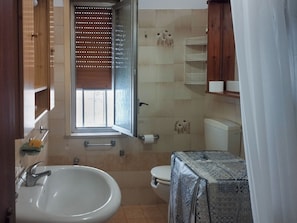 A bathroom with a sink, toilet, and window with blinds. - Casa Vacanza da Nicola 2 (Cavaliere)