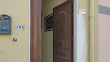 Une porte en bois portant le numéro « 258 » et une boîte aux lettres ornée d’un blason.