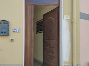 Eine Holztür mit einer Nummernschild '258' und einem Briefkasten mit Wappen.
