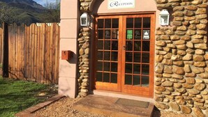 A stone building with a reception area, wooden door, and a stone wall.