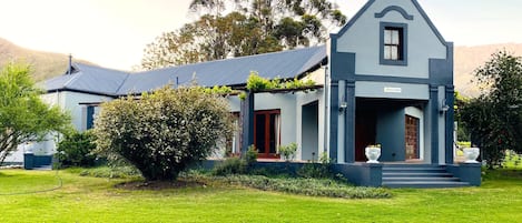 A two-story house with a gabled roof, a front porch, and a small garden area.