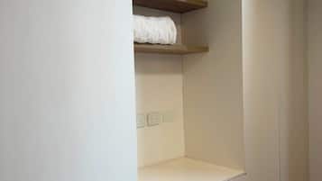 Guarda-roupa branco com prateleira suspensa e gavetas na parte inferior.